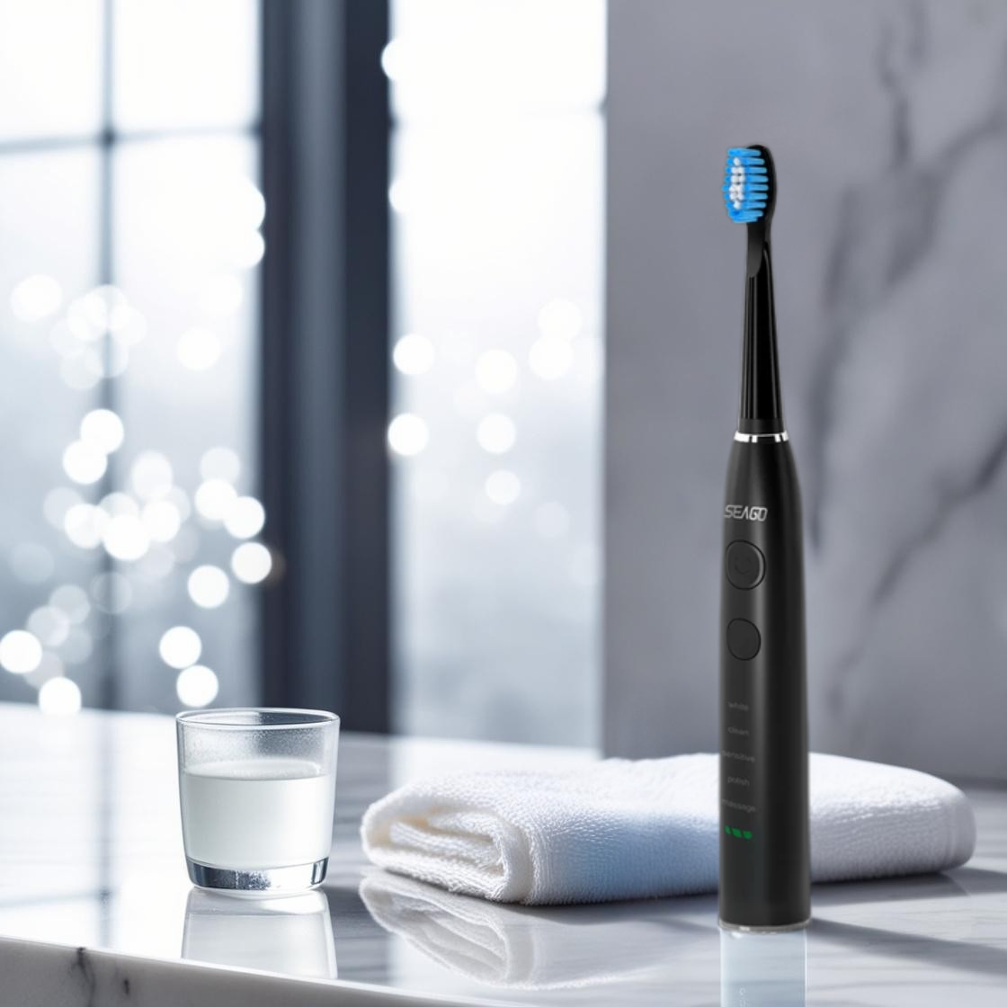 Black electric toothbrush on a marble surface with a glass of water and a towel in the background.