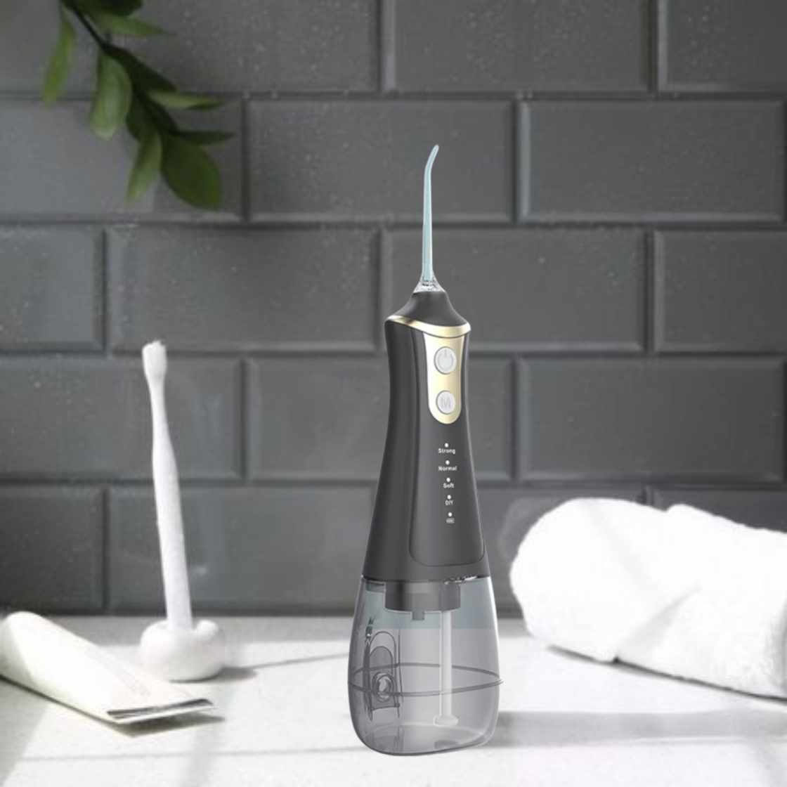 Black dental water flosser on a white surface with a gray tiled wall background